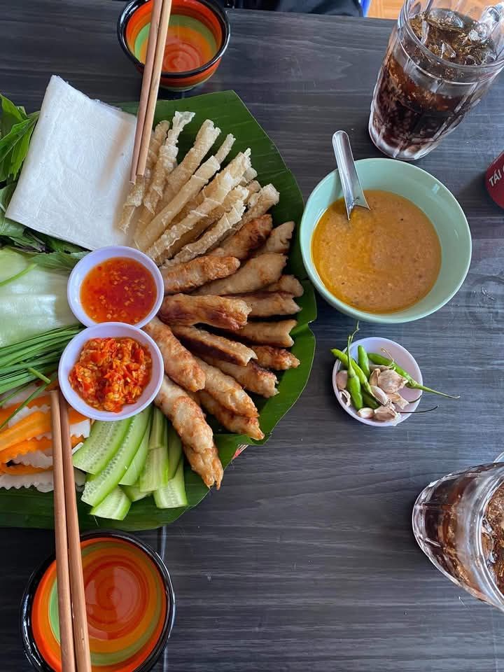 Nem nướng Da Lat – Grilled pork skewers with rice paper and fresh vegetables.