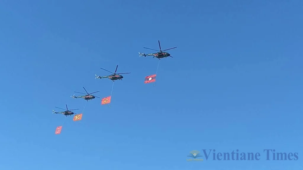 Helicopters carrying the Lao national flag in the sky